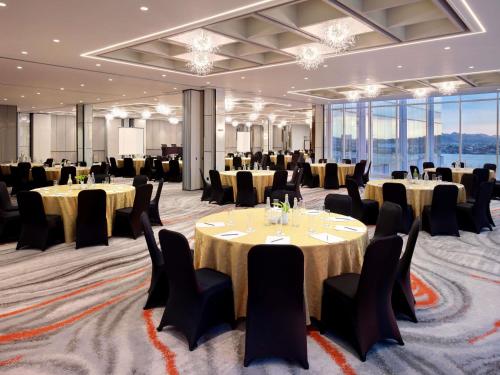 a ballroom with tables and chairs and a room with windows at Mercure Samarinda in Samarinda