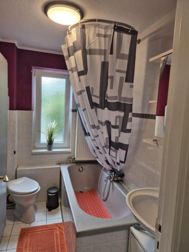 a bathroom with a tub and a toilet and a sink at Ferienwohnung Resi in Lübeck