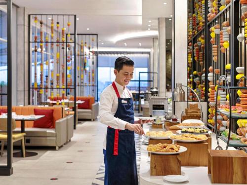 a man is preparing food in a restaurant at Ibis Samarinda in Samarinda