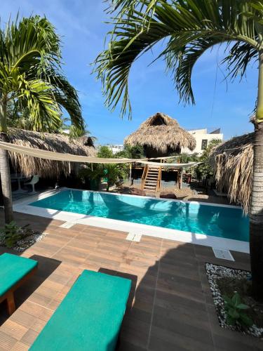 una piscina con palmeras y un complejo en KokohauBungalows, en Santa Verónica