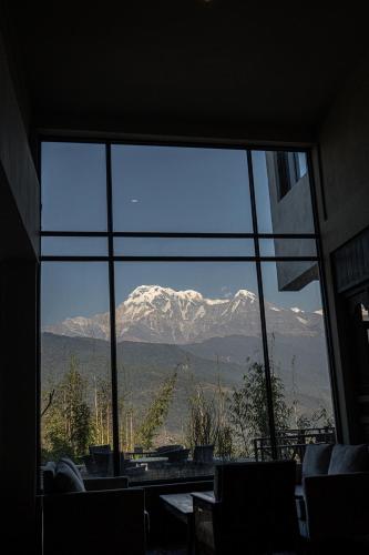 a view of a mountain through a large window at Nana Mountain Resort Mt Annapurna View in Astam