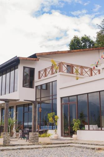 a white building with glass windows at Nana Mountain Resort Mt Annapurna View in Astam