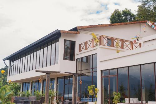 a large white building with glass windows at Nana Mountain Resort Mt Annapurna View in Astam