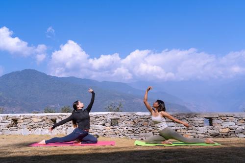 two women are doing yoga on a wall at Nana Mountain Resort Mt Annapurna View in Astam