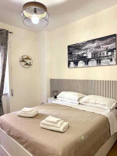 a bedroom with a bed with two towels on it at Casa Blaserna nel Cuore dello Shopping a Marconi e Trastevere in Rome