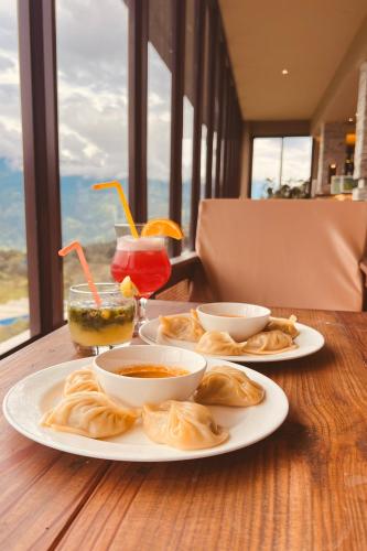 a table with plates of food and drinks on it at Nana Mountain Resort Mt Annapurna View in Astam