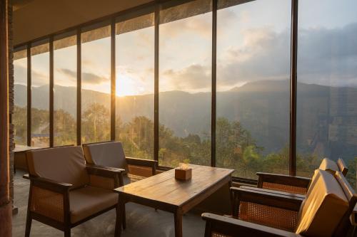a room with a table and chairs and a large window at Nana Mountain Resort Mt Annapurna View in Astam