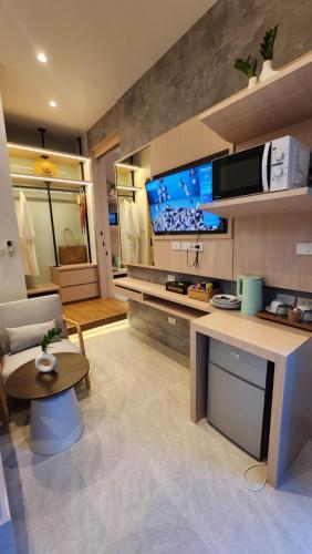 a living room with a couch and a tv at Alaita Boutique Phuket in Ban Bo Rae