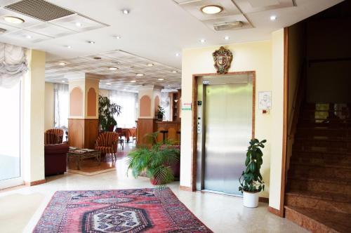 a lobby with a door and a rug at Hotel Visconti in Melzo