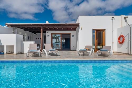 a villa with a swimming pool and a house at Villa Nitho in Playa Blanca