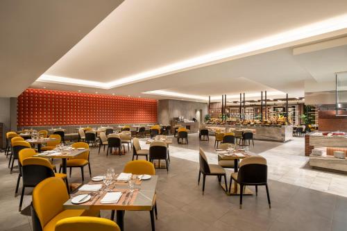 a restaurant with tables and chairs and a bar at Movenpick Makkah Hajar Tower in Makkah