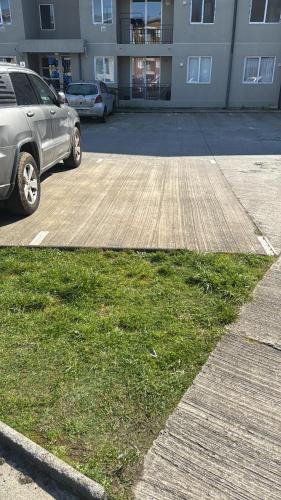 a parking lot with a car parked in front of a building at Furnished apartment Puerto Montt in Puerto Montt
