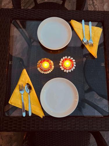 a table with plates and utensils on a glass table at Hotel the shore by Trindra Hospitality in Rishīkesh