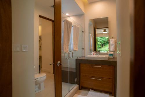 Un baño con ducha, inodoro y lavabo. en Casa Selva Tica 6 bdr pool golf view in Los Suenos, en Herradura
