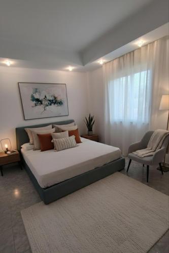 a bedroom with a large bed and a chair at La Ginestra Dell' Etna in Adrano