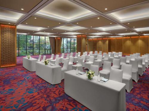 ハノイにあるGrand Mercure Hanoiの白いテーブルとピンクの椅子のある会議室