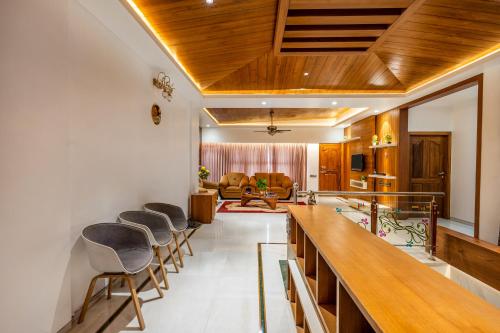 a group of chairs lined up in a living room at HSR Penthouse Spacious 4-BHK Apartment with Living, Lounge Area, Study Room, Terrace & Balconies in Bengaluru