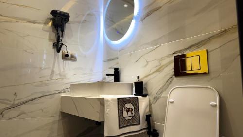a bathroom with a white sink and a mirror at Luxury Hermes Apartement Marina View-Mall-Parking in Tangier