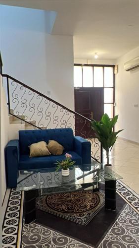 a living room with a blue couch and a table at Khalifa A Home Stay Small Room in Sabkhah