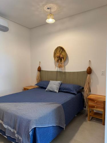 une chambre avec un lit avec une couette bleue dans l'établissement Suítes BG - Rua principal de Barra Grande, à Barra Grande