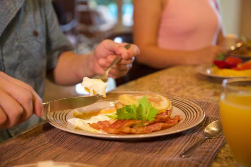 a person eating a plate of food on a table at Colina 7C 3 bdr Garden View in Los Suenos in Herradura