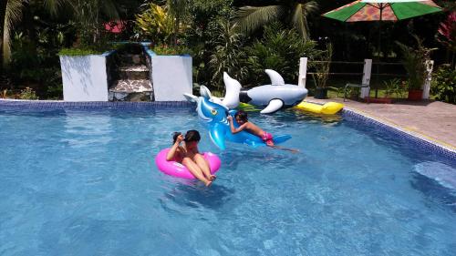 Dos chicas están montando en un flotador en una piscina en Caribbean Paradise, en Tortuguero