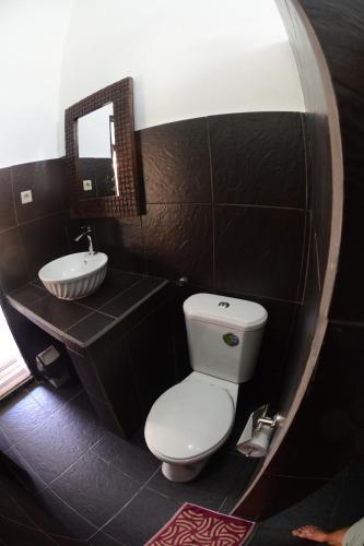 a bathroom with a white toilet and a sink at Relaxing Homestay in Kuta Lombok