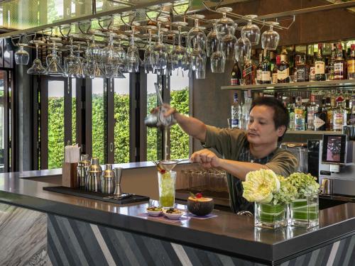 a man behind the bar at a restaurant at Grand Mercure Khao Lak Bangsak in Khao Lak