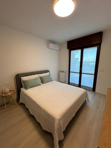 a bedroom with a large bed with a large window at Casa Rovedine in Opera