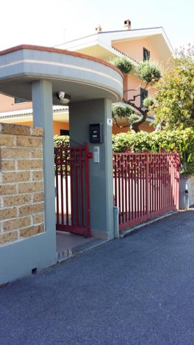 a house with a red gate and a building at B&B Mirella in Citta' Sant'Angelo