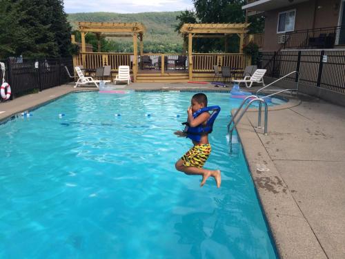 un joven saltando a una piscina en The Sundowner on Lake George, en Lake George
