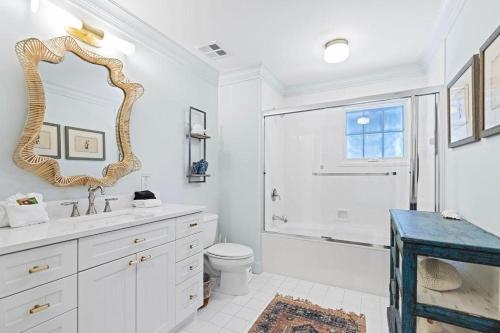 Un baño con lavabo, inodoro y espejo. en Ave 30A by Coastal Dreamin, en Santa Rosa Beach