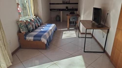 a living room with a couch and a table and a television at Casa Albatroz - primeira locaçao 4 suites in Búzios