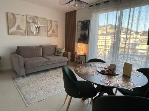 カンヌにあるAppartement proche croisetteのテーブルと椅子とソファのあるリビングルーム