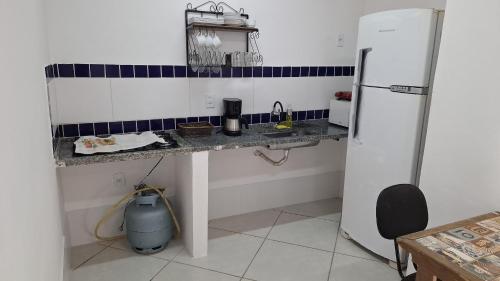 a kitchen with a counter and a refrigerator at Casa Albatroz - primeira locaçao 4 suites in Búzios