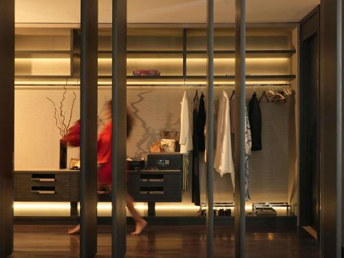 a woman standing in a closet with a dresser at Fairmont Riyadh in Riyadh