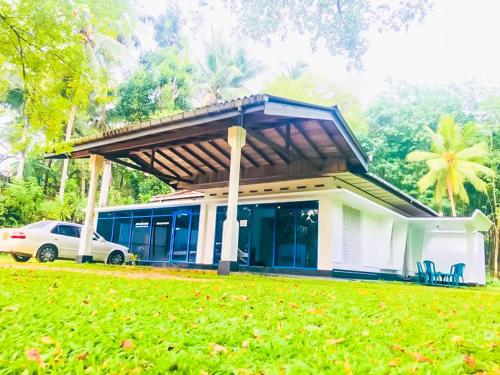 a house with a car parked in front of it at Hotel Rays Lanka Avissawella in Avissawella