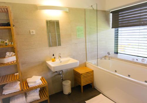 a bathroom with a sink and a bath tub and a sink at eco boutique hotel AMS Beagle in Bled