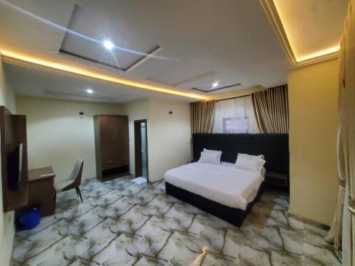a hotel room with a bed and a desk at Prym Hotel in Owerri