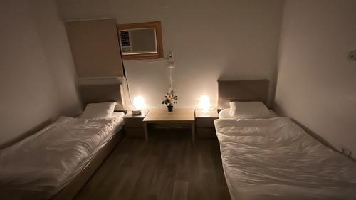 Habitación con 2 camas y mesa con luces. en Quba Peace سلام قباء, en Medina