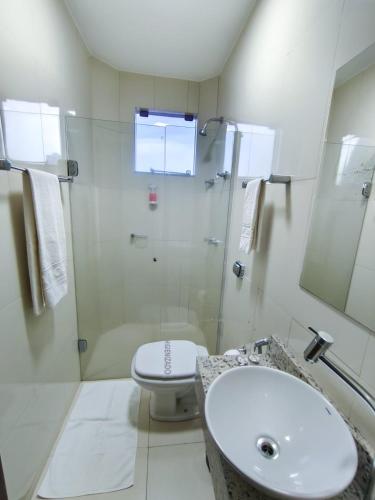 a bathroom with a shower and a toilet and a sink at Arca's Hotel Umuarama in Umuarama