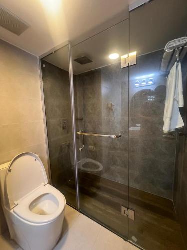 a bathroom with a toilet and a glass shower at Hotel Kollol by J&Z Group in Cox's Bazar