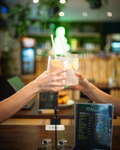 twee mensen met een drankje in hun handen bij Nova City Apartments in Boedapest