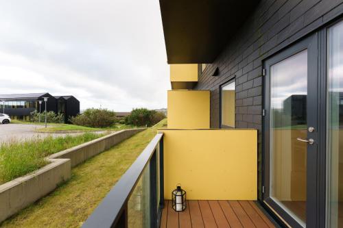 a house with a yellow door on a balcony at Unwind in Style - 2 BR - Hiking - Family in Tórshavn