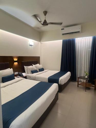 a hotel room with two beds and a ceiling fan at Hotel Kollol by J&Z Group in Cox's Bazar