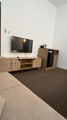 a living room with a flat screen tv on the wall at Khalifa A Home Stay NR in Abu Dhabi