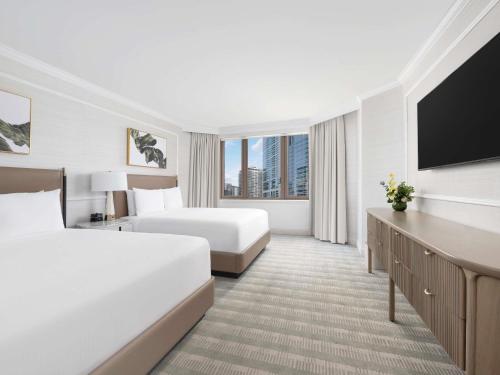 a hotel room with two beds and a flat screen tv at Fairmont Chicago Millennium Park in Chicago