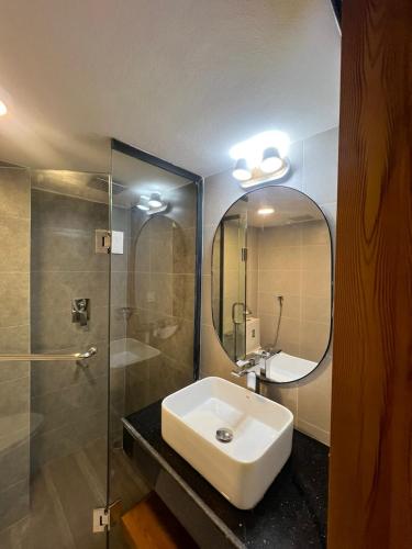 a bathroom with a sink and a shower and a mirror at Hotel Kollol by J&Z Group in Cox's Bazar