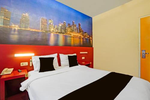 マランにあるTownhouse Oak Malang near ITN Malang formerly Fariz Hotel Singosariの大きなベッド付きのベッドルーム1室、壁に絵画が飾られています。