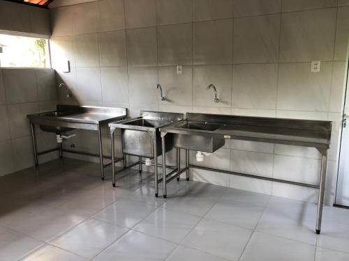 a kitchen with three sinks in a room at Sitio Bangue in Camaragibe